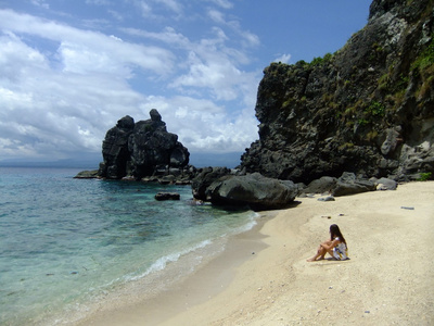 年轻女子坐在穿裙子的热带海滩