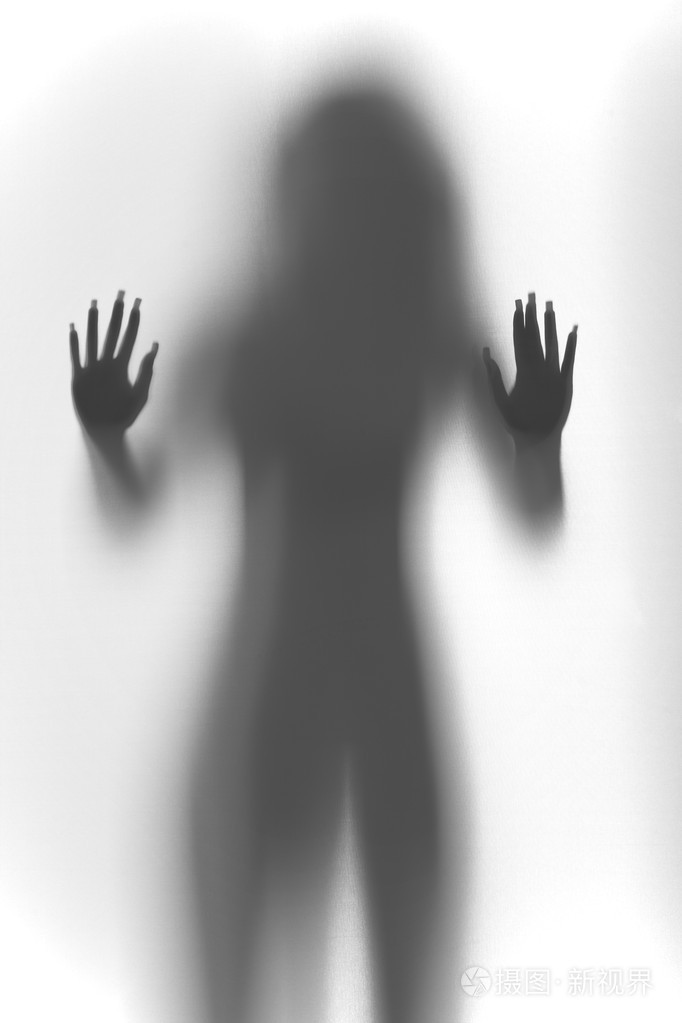 性感的女人站在窗帘后面剪影