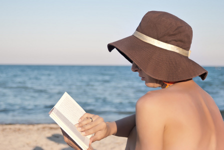 女人看了书在海滩上