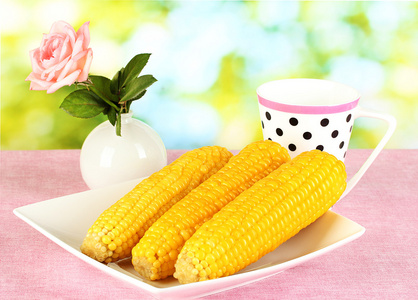煮的玉米对自然的背景上粉色桌布