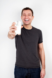 年轻男子微笑着用一杯牛奶