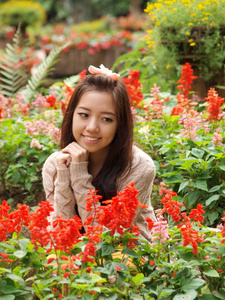 亚洲漂亮女孩创辉花卉背景上的微笑