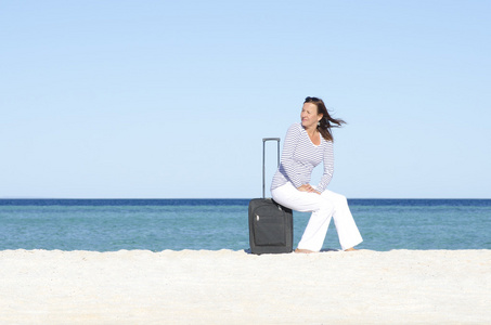 单身女人带行李在海边等图片