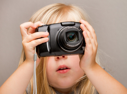 年轻的孩子拿着照相机拍摄图片图片