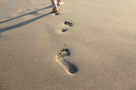 年轻的红发女孩人类的脚印人类的脚印在沙滩上散步海滩上,无水的脚