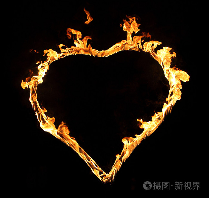 燃烧着火焰的心在黑暗的背景上孤立
