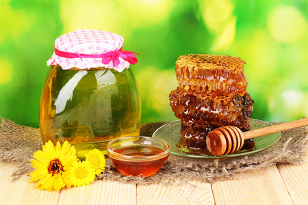 罐蜂蜜和自然背景上的木桌上蜂窝