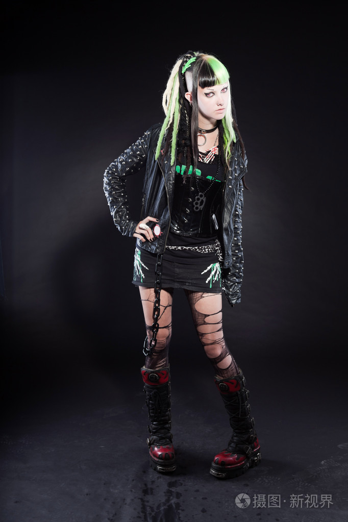 数码朋克女孩与绿色的金发和红红的眼睛被隔绝在黑色背景上表情丰富的