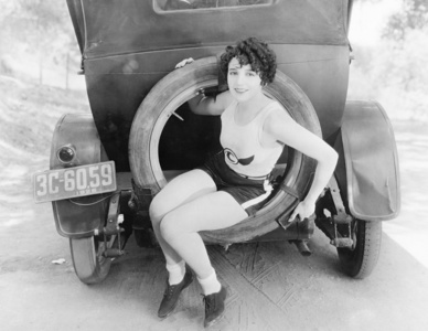 年轻的女人坐在一辆车的车轮