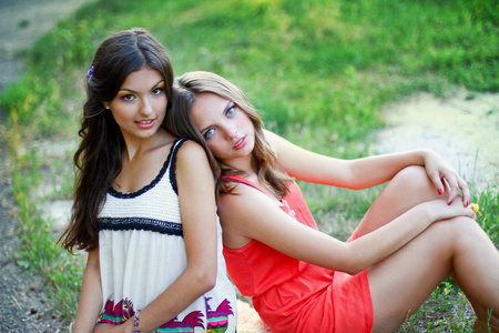两名年轻妇女在坐在一起的衣服