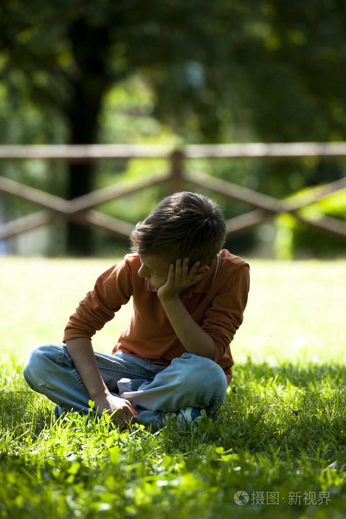 坐在户外的伤心担心小男孩