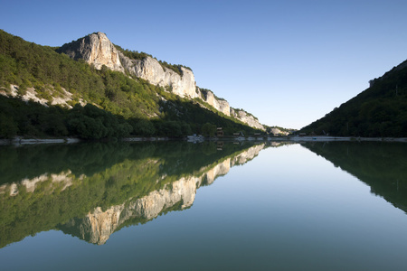 岩石和绿色山反映在湖边