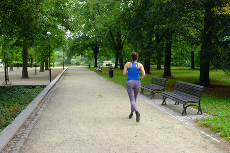 年轻美丽的白种女人在夏天公园慢跑