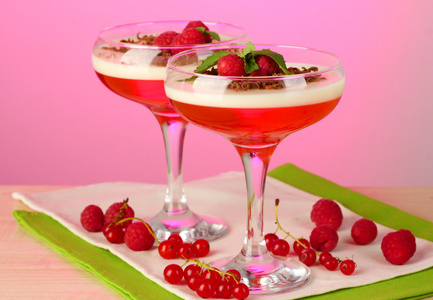 水果果冻的浆果在粉红色的背景上的木桌上的眼镜