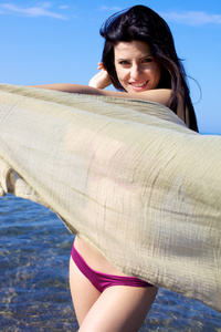 快乐的女模特，在海滩上玩的面纱