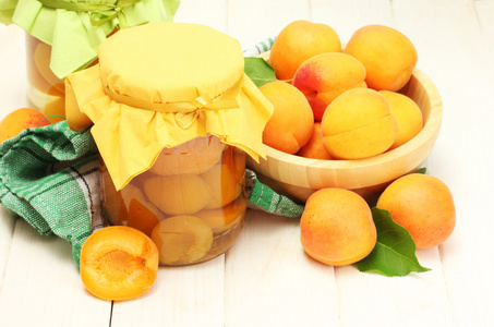 杏子在罐子 白色的木桌上的碗里成熟杏子罐头