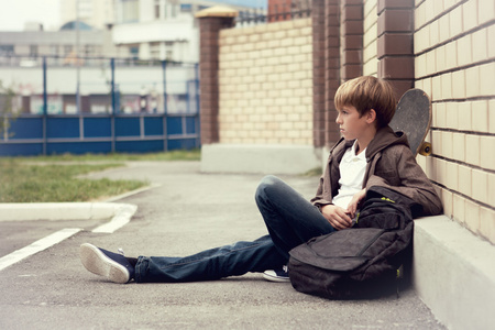 学校青少年与 schollbag 和滑板