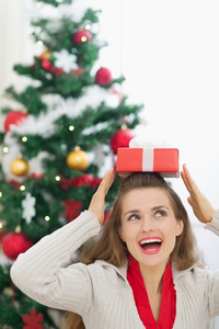 快乐的年轻女人，举行圣诞礼物箱头上