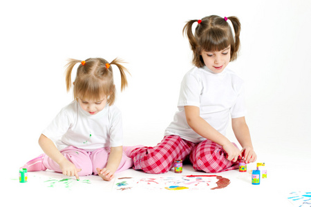 两个小女孩在白色背景上绘画