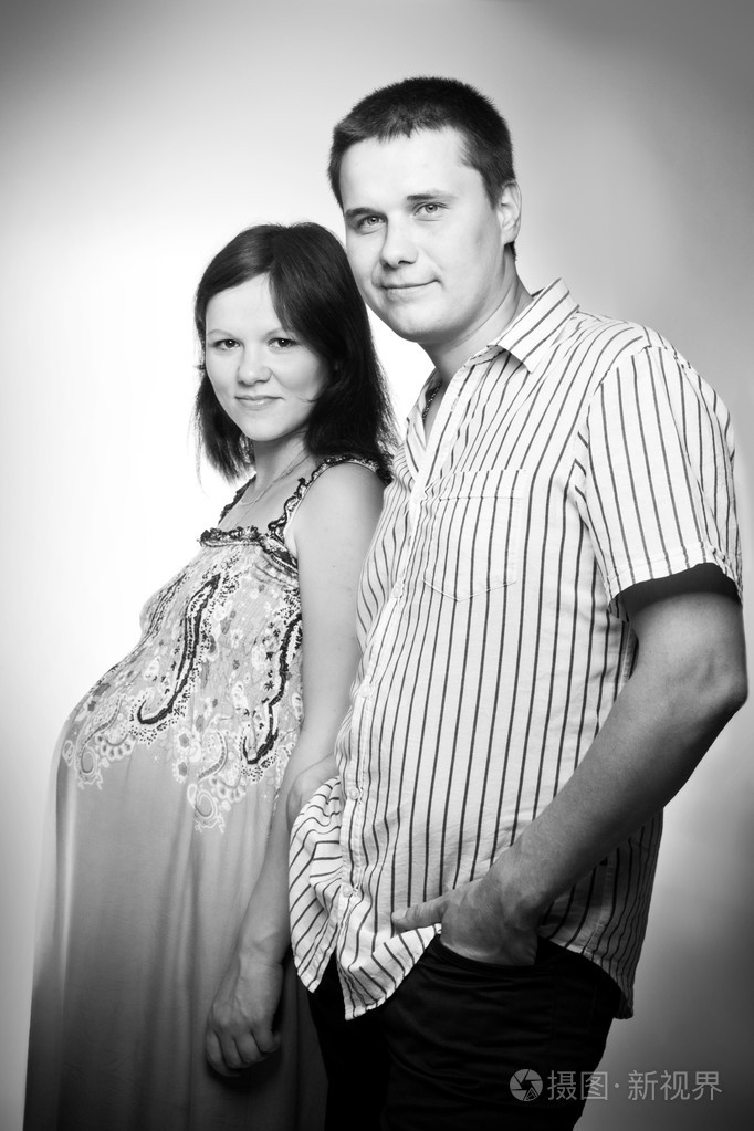 年轻的白种人的怀孕的夫妇的黑色和白色工作室肖像