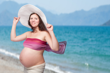 glad vacker ung gravid kvinna vid havet快乐美丽年轻的孕妇在海边