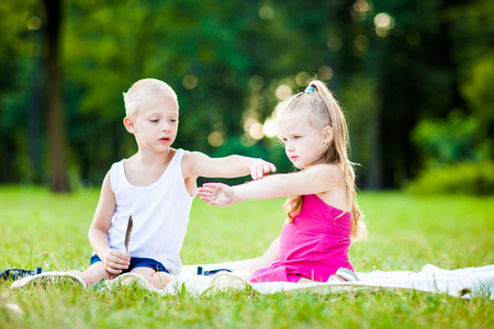 小男孩和女孩与瓢虫在公园