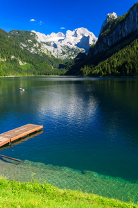 木码头与绿色水晶般清澈的高山湖泊旅游船舶
