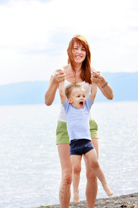 幸福的母亲和儿子在海滩上玩