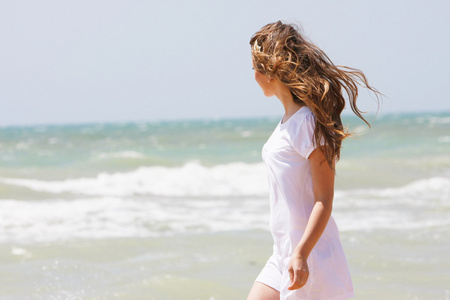 年轻快乐的女孩走在海面背景
