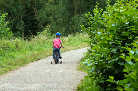 男孩骑自行车穿过树林
