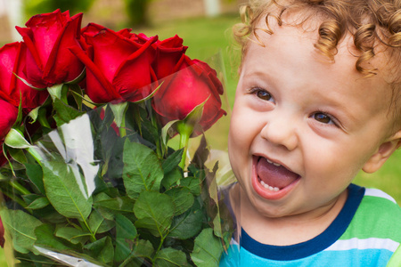 快乐的孩子用一束红玫瑰