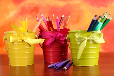 彩色铅笔和毡尖笔在彩色背景上桶