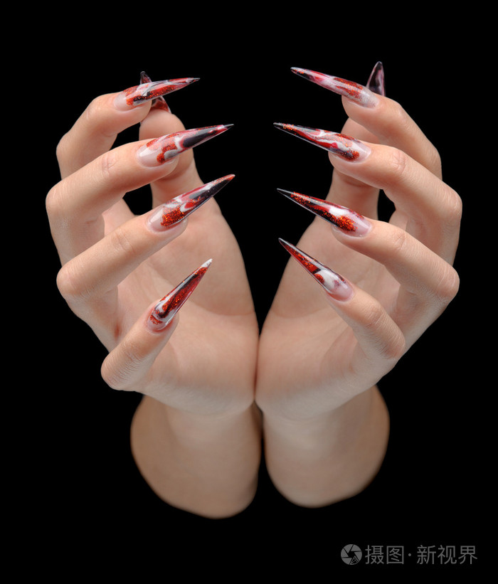 年轻女子长美甲修指甲在指甲上的手的特写