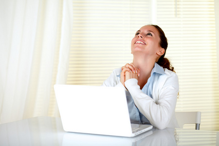 快乐的女人在笔记本电脑上工作和查找