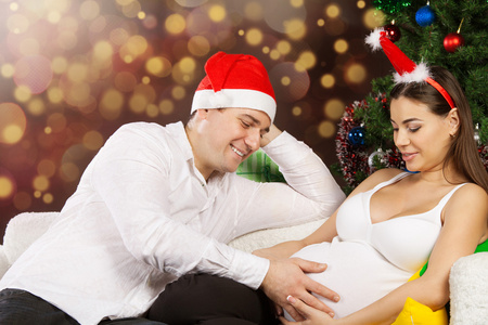 快乐怀孕夫妇附近的圣诞树