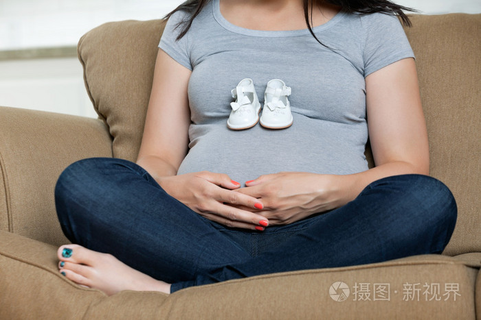 在她的肚子里的婴儿鞋的孕妇