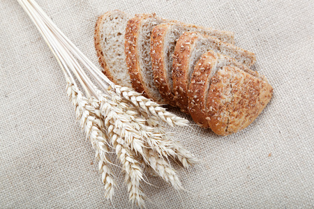 新鲜的面包用小麦在画布上的耳朵
