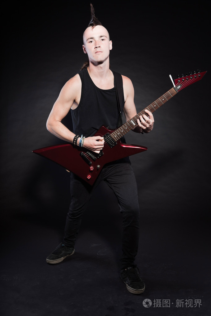 与红色电吉他和莫霍克发型朋克摇滚人表情丰富的脸孤立在黑色背景上