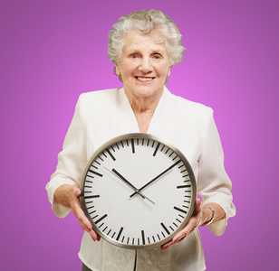 在紫色的幸福的高级女人控股时钟的肖像