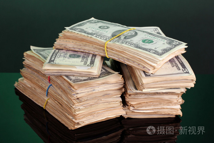 成堆的美元在绿色背景上