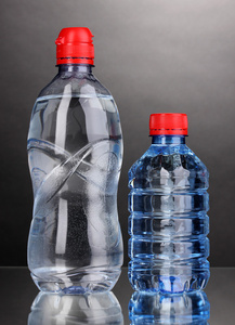 灰色背景上水的塑料瓶
