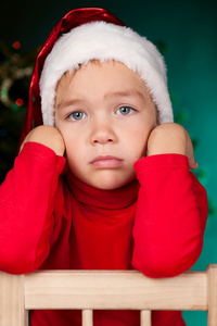 伤心的小男孩在圣诞老人帽子