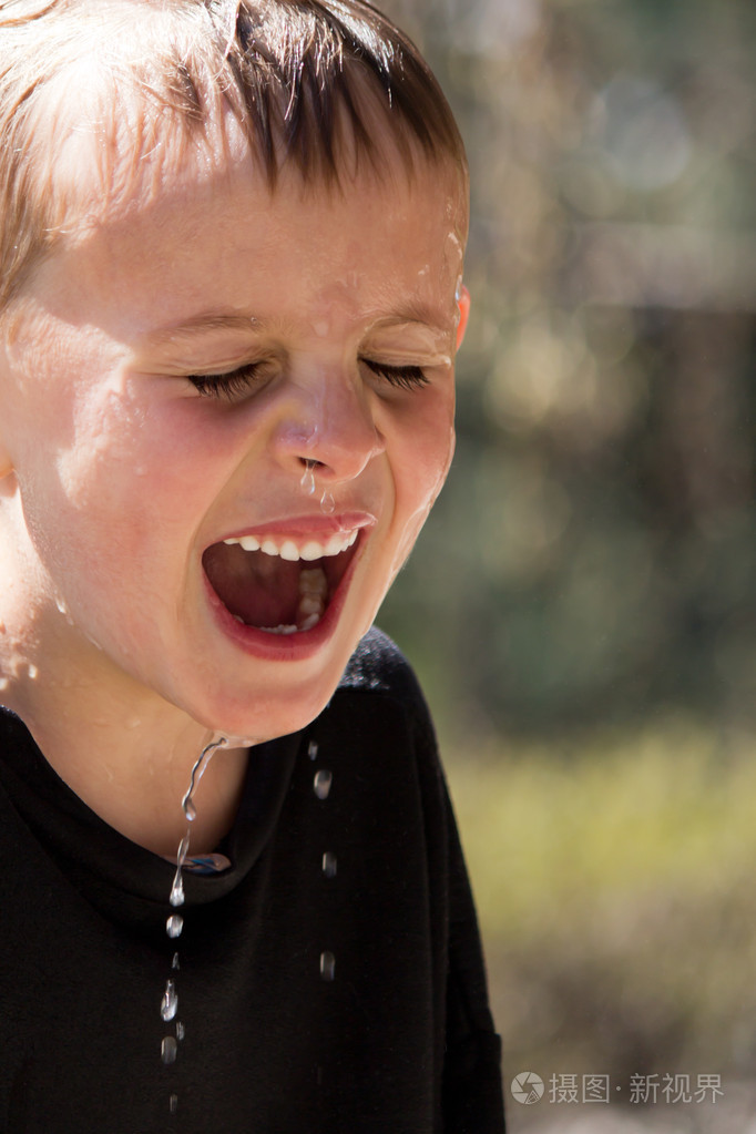 浸泡湿年轻男孩的狂笑