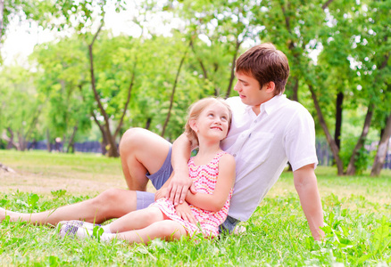 父亲和女儿一起坐在草地上