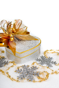 在雪上的金色丝带圣诞银心礼品盒