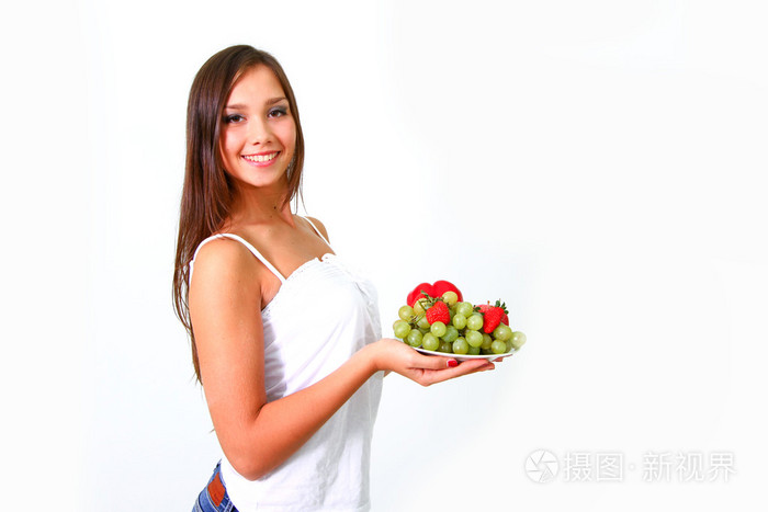 年轻女子在一碟上的蔬菜和水果