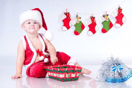 可爱宝贝圣诞老人与圣诞购物篮和花环