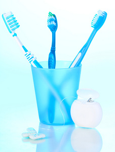 玻璃 牙线 口香糖在蓝色背景上的牙刷