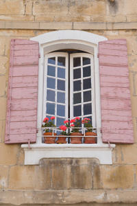 带有粉红色百叶窗的传统法国窗口。