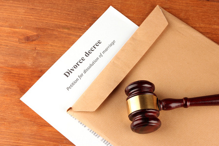 离婚法令和木制背景上的信封